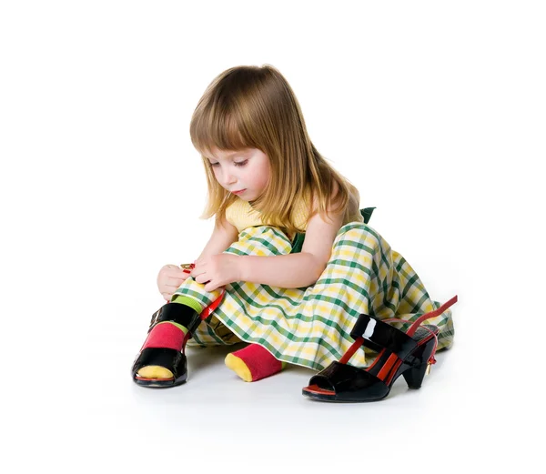 Kleines Mädchen probiert große Schuhe an — Stockfoto