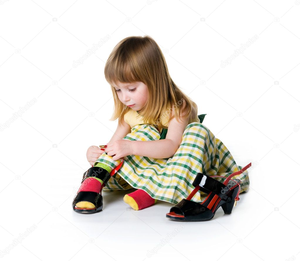 Little girl try on big shoes