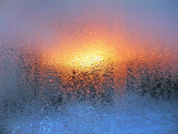 Natural water drops and sunlight on window glass