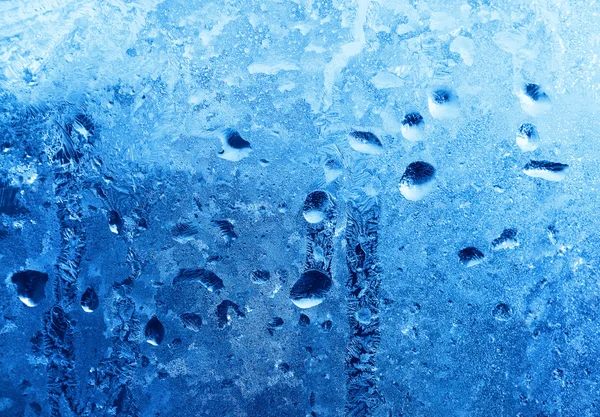 Zmrzlé vody klesne na zimu sklo — Stock fotografie