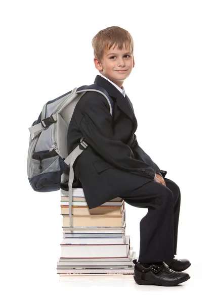 Schoolboy sitting on books — Stock Photo, Image