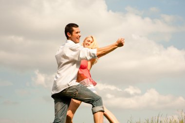 Young couple walking through summer lawn clipart