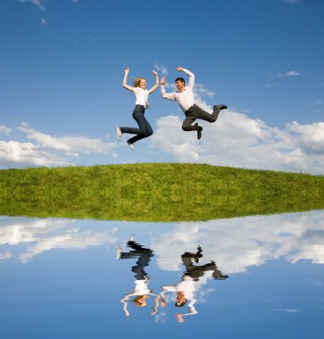 Happy smiling couple jumping in blue sky clipart