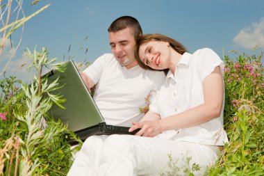bir dizüstü bilgisayarda açık havada rahat mutlu çift