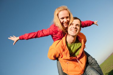 Young couple walking through summer lawn clipart