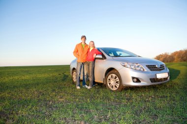 Happy young couple with new car clipart