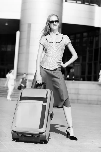 Vacker flicka med en resväska mot bakgrund av stati — Stockfoto
