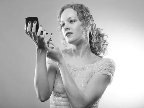 Mulher bonita aplicando maquiagem com pó. Foto preto e branco — Fotografia de Stock
