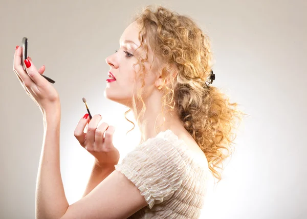 Mulher bonita aplicando maquiagem com pó — Fotografia de Stock