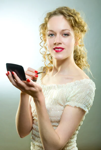 Pretty woman applying make-up with powder — Stock Photo, Image
