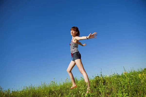 Šťastná mladá žena skákání v poli — Stock fotografie