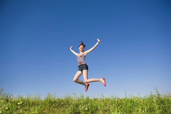 Щаслива молода жінка стрибає в полі — стокове фото