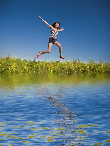 Felice giovane donna che salta in un campo — Foto Stock