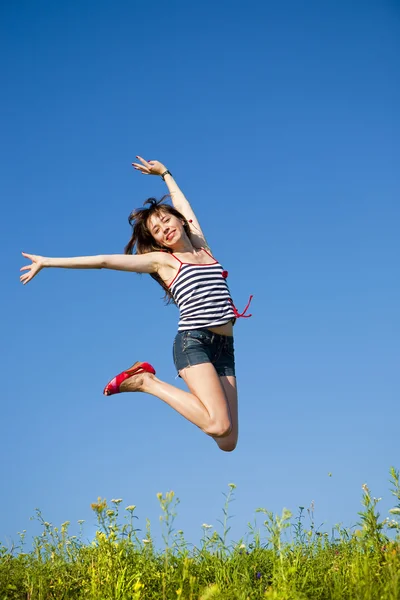 Felice giovane donna che salta in un campo — Foto Stock