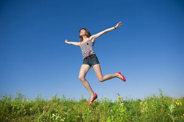 快乐的年轻女子在田间跳跃 — 图库照片