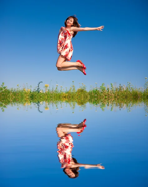 フィールドに跳躍幸せな若い女性 — ストック写真