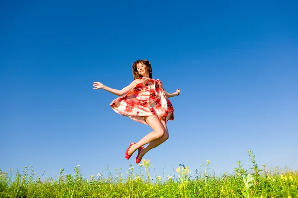 Szczęśliwa młoda kobieta jest skakanie w polu — Zdjęcie stockowe