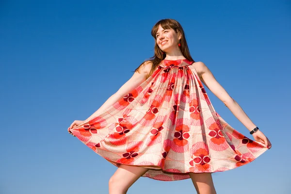 Chica feliz huyendo en un prado. En vestido rojo y zapatos rojos. Agai. —  Fotos de Stock