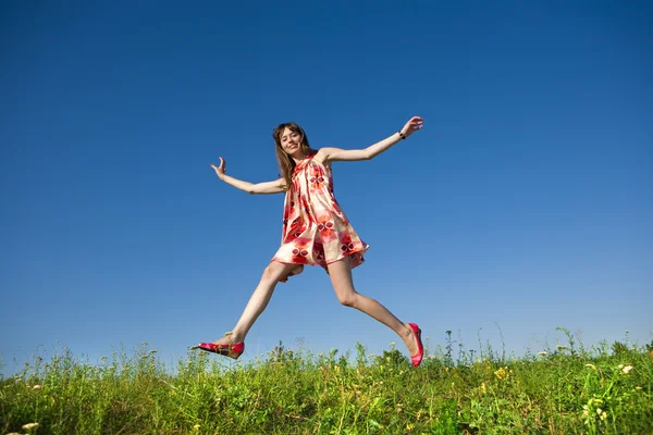 フィールドに跳躍幸せな若い女性 — ストック写真