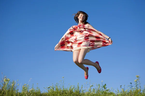 Happy young woman jumping in a field — Stock Photo, Image