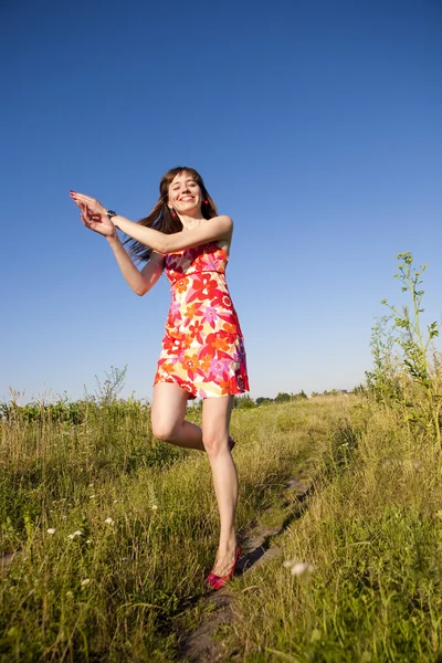Boldog fiatal nő, ugrás a területen — Stock Fotó
