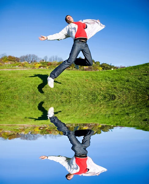 Gelukkig jonge man - springen einde vliegt in blauwe hemel — Stockfoto