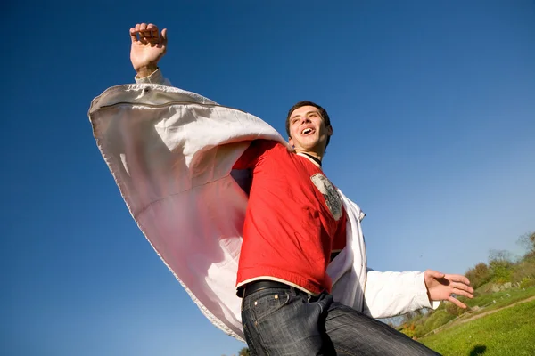 Happy young man flies in blue sky — Stock Photo, Image