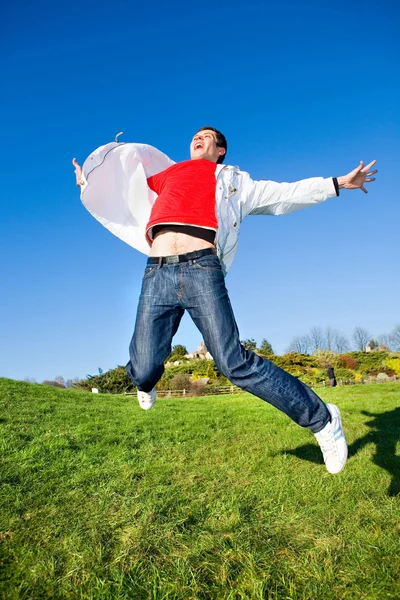 Glücklicher junger Mann - Sprungende fliegt in blauem Himmel — Stockfoto