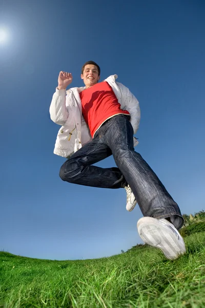 Счастливый молодой человек - прыгающий конец летит в голубом небе — стоковое фото