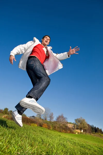 Felice giovane uomo - saltare nel cielo blu — Foto Stock