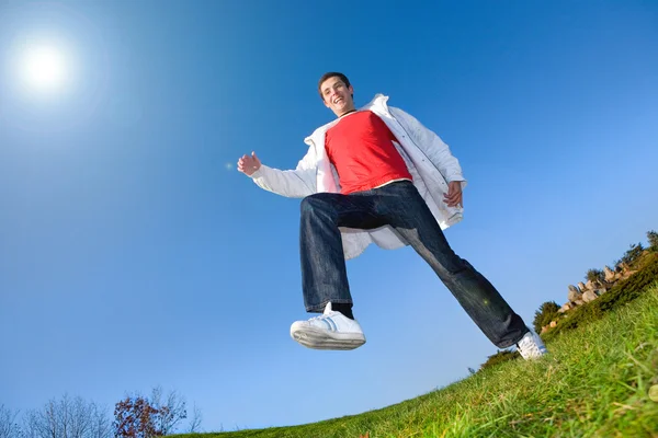 Szczęśliwy młody człowiek - skoki koniec leci w błękitne niebo — Zdjęcie stockowe