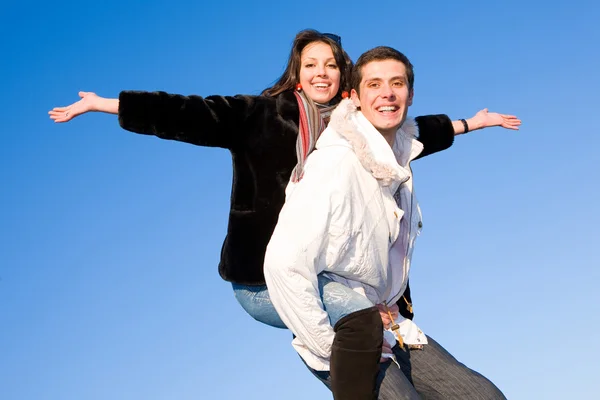年轻的爱夫妇微笑结束下蓝蓝的天空飞 — 图库照片