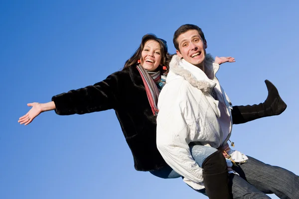Счастливая молодая влюбленная пара - прыжки под синим небом — стоковое фото