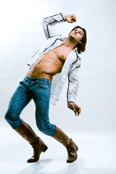时尚拍摄的一个年轻男人时尚的欧洲男人穿着当代布 一件白衬衫 牛仔裤和靴子的人 光秃秃的躯干 — 图库照片