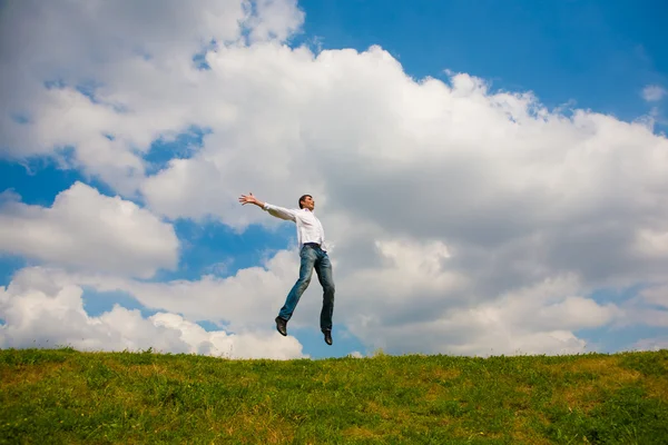 Happy young man - jumping against backdrop of blue sky. — Stock Photo, Image