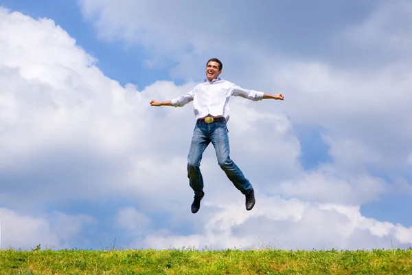 L'uomo felice sta saltando su un campo — Foto Stock