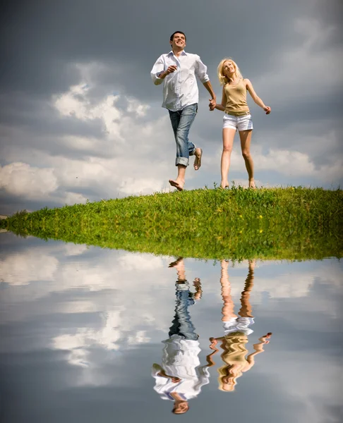 여름 잔디밭을 통해 걷는 젊은 부부 — 스톡 사진