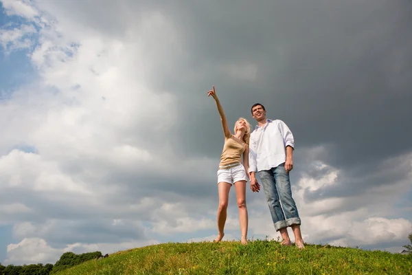 Молода пара гуляє по літньому газону — стокове фото