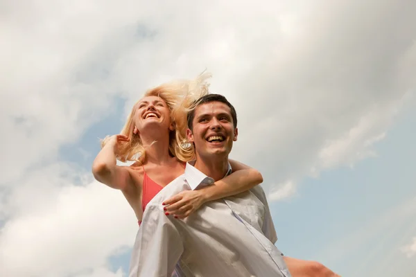 Happy young couple jumping in sky — Stock Photo, Image