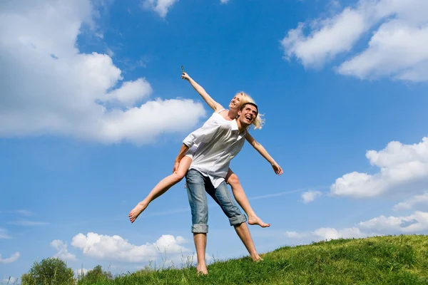 Szczęśliwa Młoda Para Skoki Niebo Nad Zielony Łąka — Zdjęcie stockowe