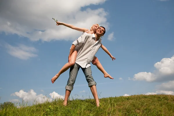 夏の芝生を歩く若いカップル — ストック写真