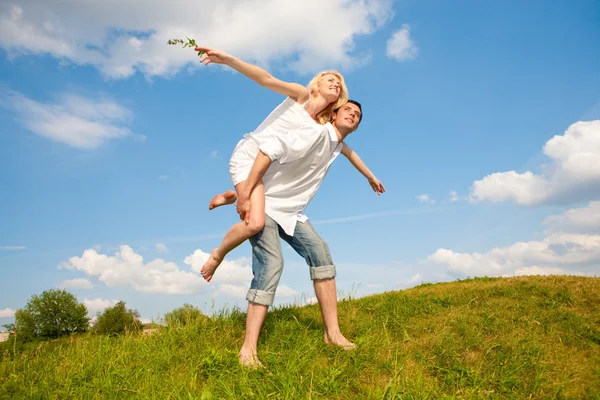 Szczęśliwa Młoda Para Skoki Niebo Nad Zielony Łąka — Zdjęcie stockowe