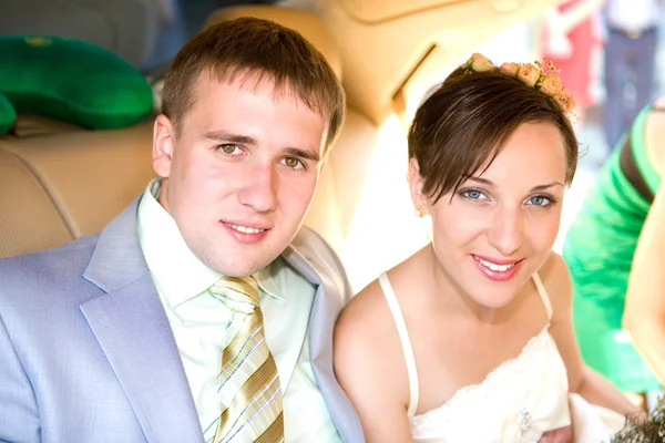 肖像微笑着新郎和新娘在婚礼车 — Stock fotografie