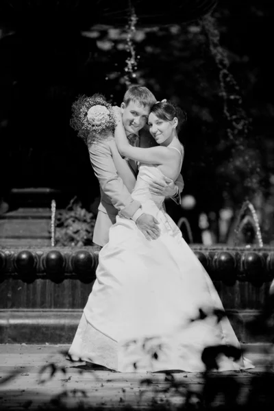 Bruid en bruidegom vreugde tegen achtergrond fontein. in alle groei. — Stockfoto