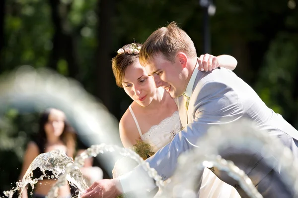 Bruid en bruidegom vreugde in fontein — Stockfoto