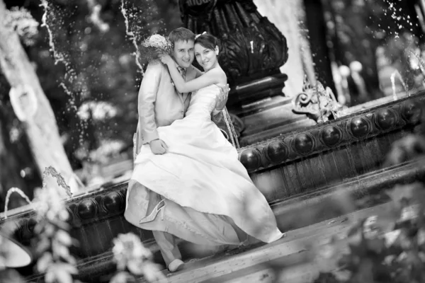 Γαμπρός και η νύφη χαρά κατά σκηνικό κρήνη. σε όλη την αύξηση — Φωτογραφία Αρχείου