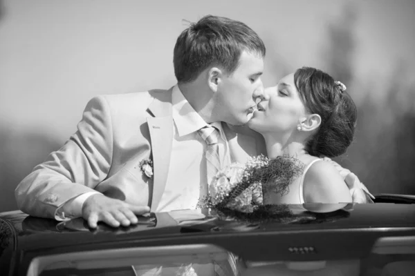 新娘和新郎的婚礼汽车上接吻 — 图库照片