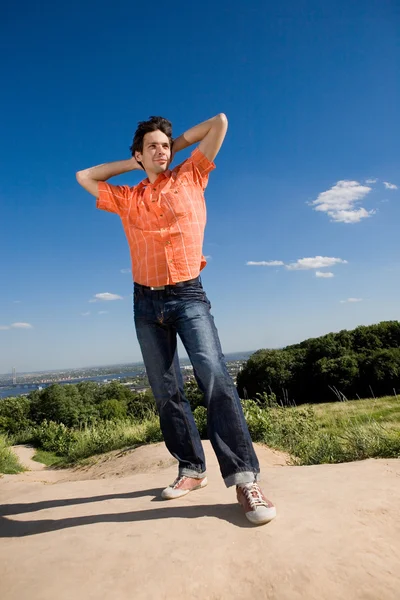Jonge man winnen op de top van een berg. tegen een blauwe hemel met — Stockfoto