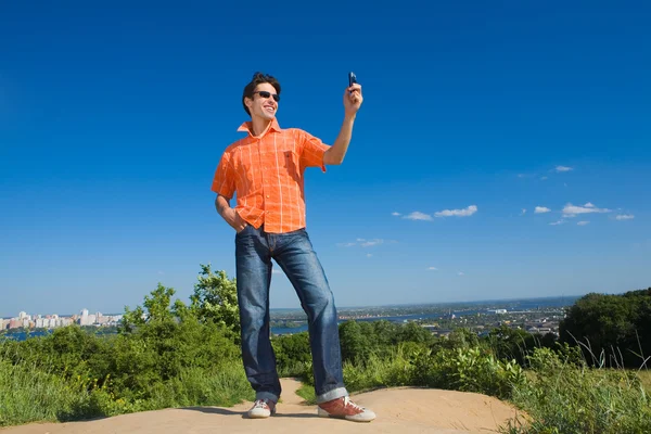 Yakışıklı genç adam onun tatil cep telefonu resim gönderme — Stok fotoğraf