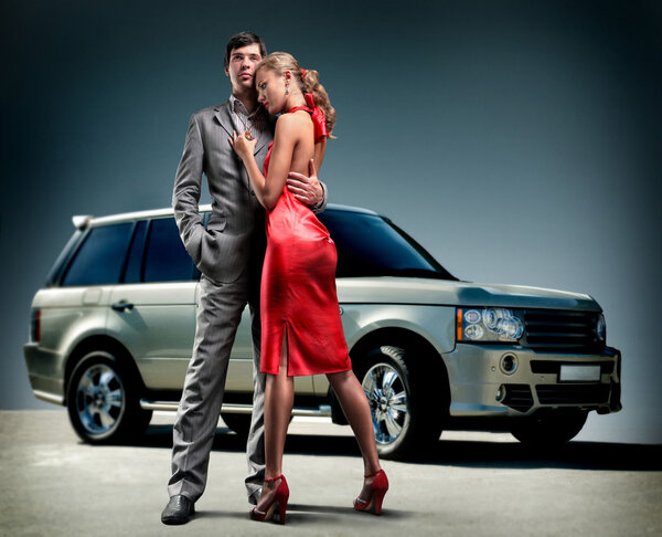 Young beautiful couple backdrop car